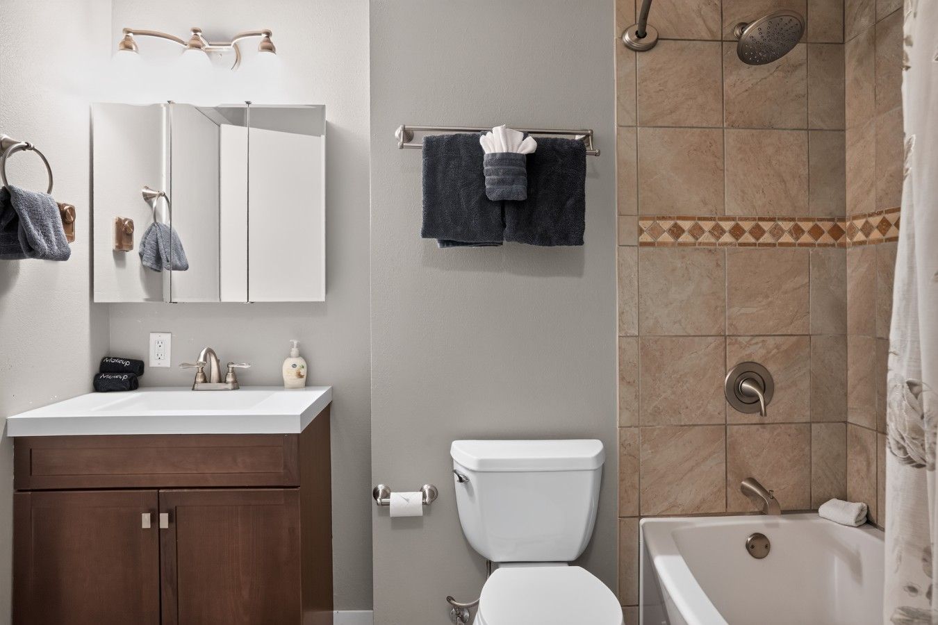 A bathroom with a white sink, a toilet, a bathtub, and a shower.