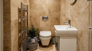 Een kleine badkamer met toilet, wastafel en handdoekhouder.