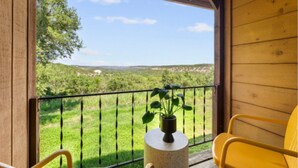 Ein Holzbalkon mit Blick auf eine grüne Landschaft.