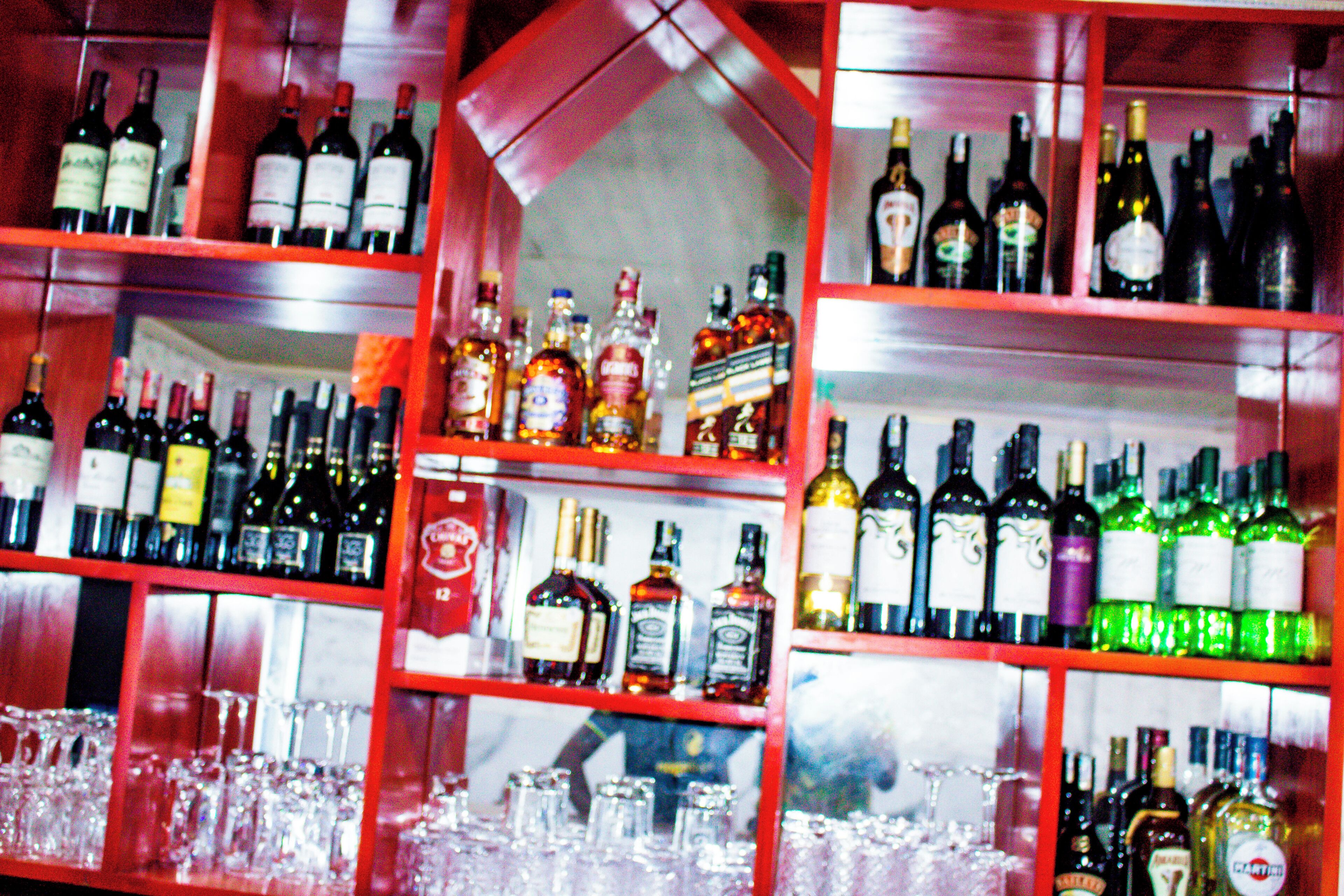 Eine Bar mit Regalen voller Spirituosenflaschen und Gläsern.