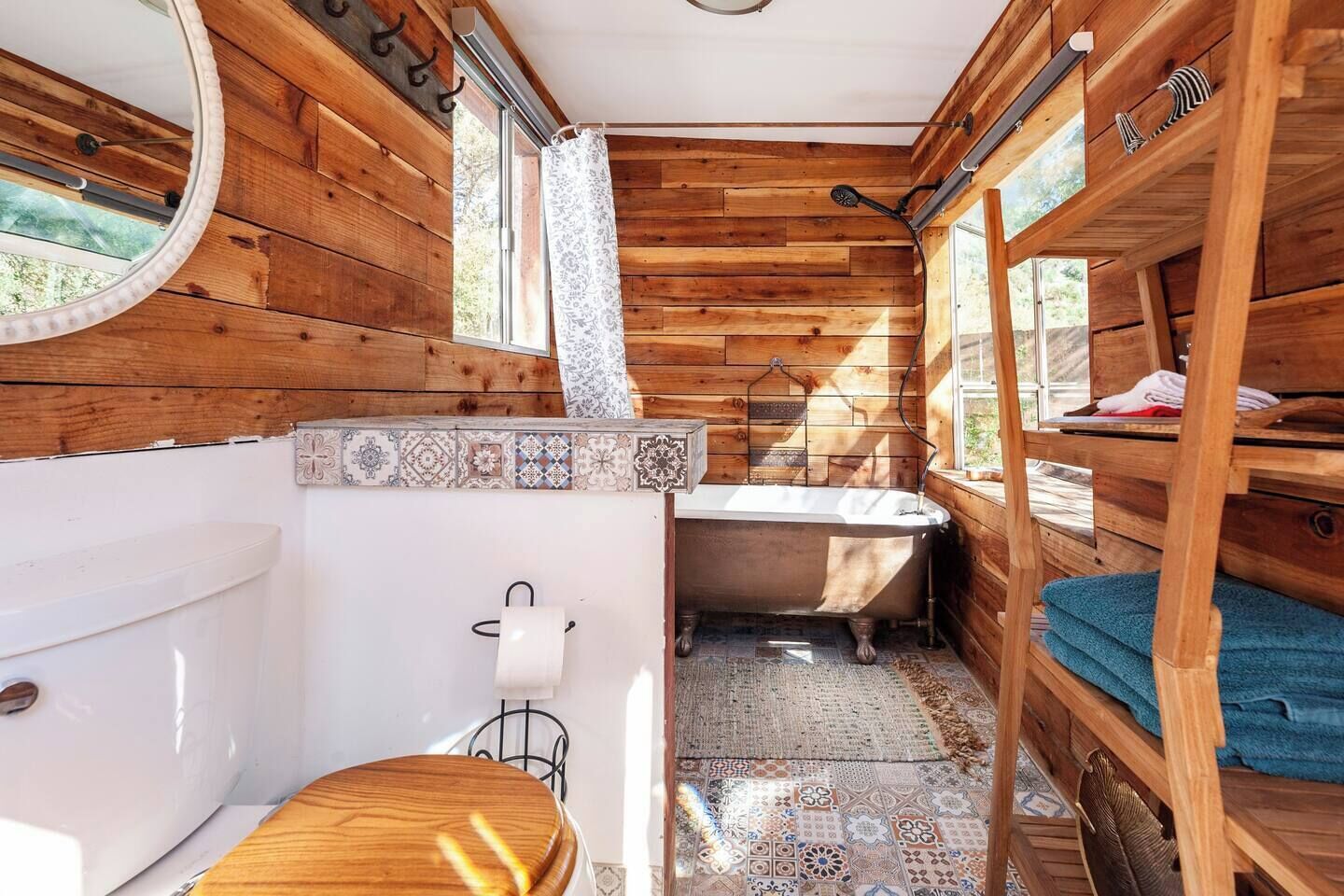 Un baño de cabaña de madera pequeño con inodoro, lavamanos y bañera.