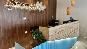 Un comptoir d’accueil avec un panneau arrière en bois et un plan de travail en marbre.
