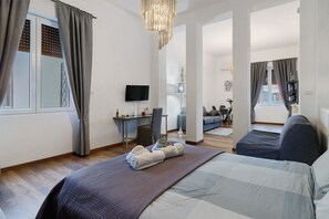 Een moderne hotelkamer met een groot bed, een bureau, een televisie en uitzicht op de stad.
