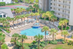 A pool surrounded by palm trees and lounge chairs, with a tennis court in the background. - Mainsail 273 - Gulf-Front, Wonderful Onsite Amenities, Free Beach Service! (Miramar Beach)