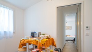 Ein Essbereich mit einem für das Frühstück gedeckten Tisch, einer Kaffeemaschine und verschiedenen Speisen.