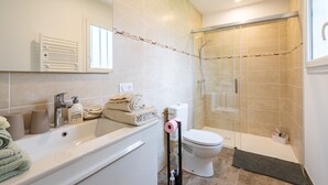 Ein Badezimmer mit Badewanne, Toilette und Duschkabine.