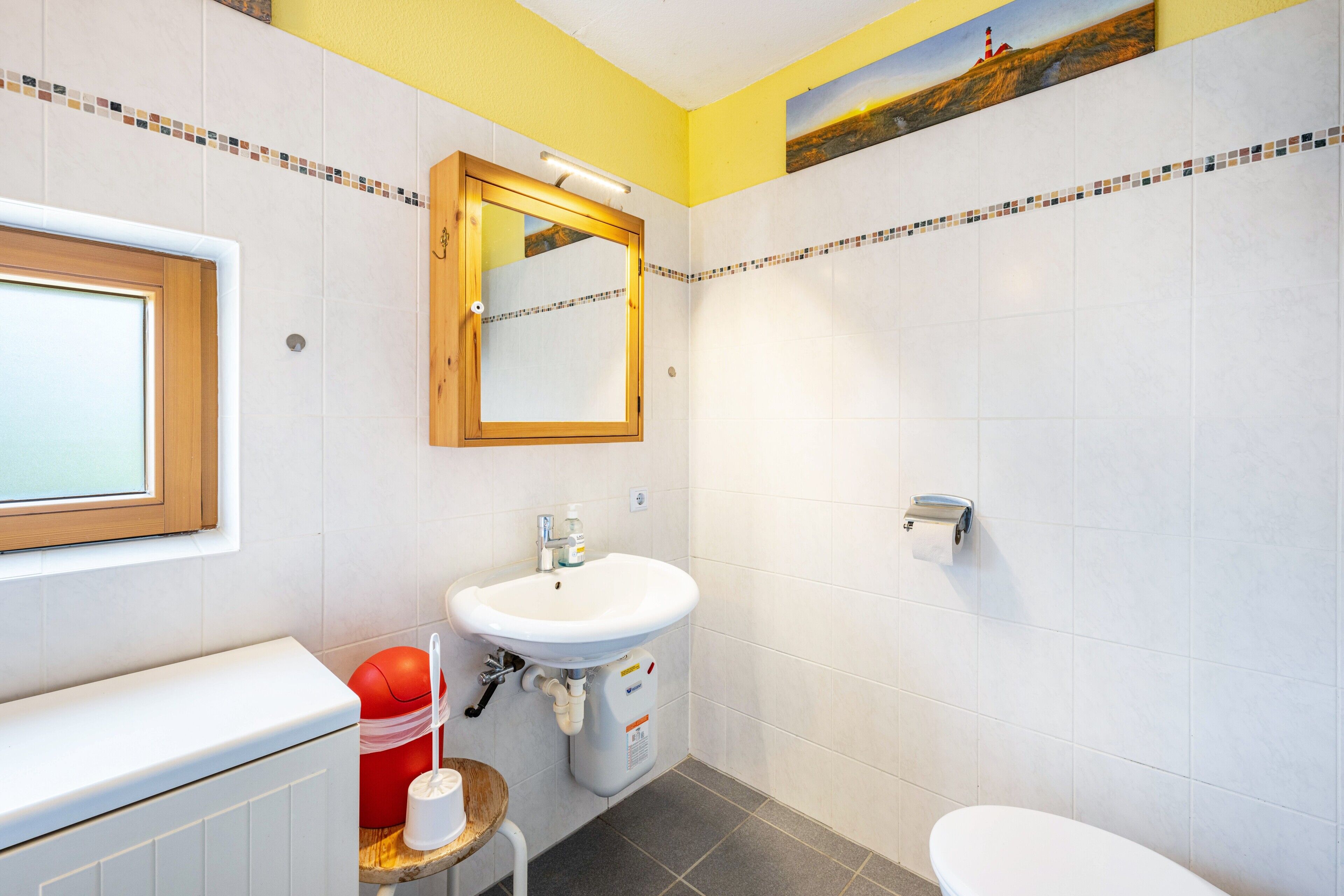 Ein Badezimmer mit Waschbecken, Spiegel und Toilette.