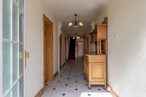 A hallway with a wooden cabinet and a chandelier. - BALLYNEILL FARMHOUSE in Carrick-On-Suir, County Tipperary (Mullagh)