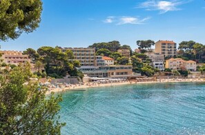 A coastal town with buildings, a beach, and clear blue water. - Apartment with sea view near Renécros beach (Bandol)