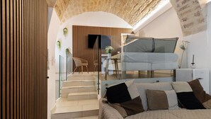 A modern interior with a bed, a sofa, a staircase, and a wall-mounted TV. - 'Lc Luxury' Apartment with Wi-Fi and Air Conditioning (Bari)