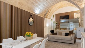 A modern living room with a dining area, a sofa, and a kitchen visible through an archway. - 'Lc Luxury' Apartment with Wi-Fi and Air Conditioning (Bari)