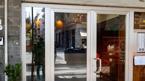 A hotel entrance with glass doors, a potted plant, and a visible interior with a staircase. - 'Salandra' Room with Wi-Fi and Air Conditioning (Bari)