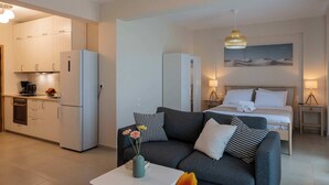 En modern lägenhet med ett kök, ett vardagsrum med soffa och soffbord samt ett sovrum med säng och sängbord.