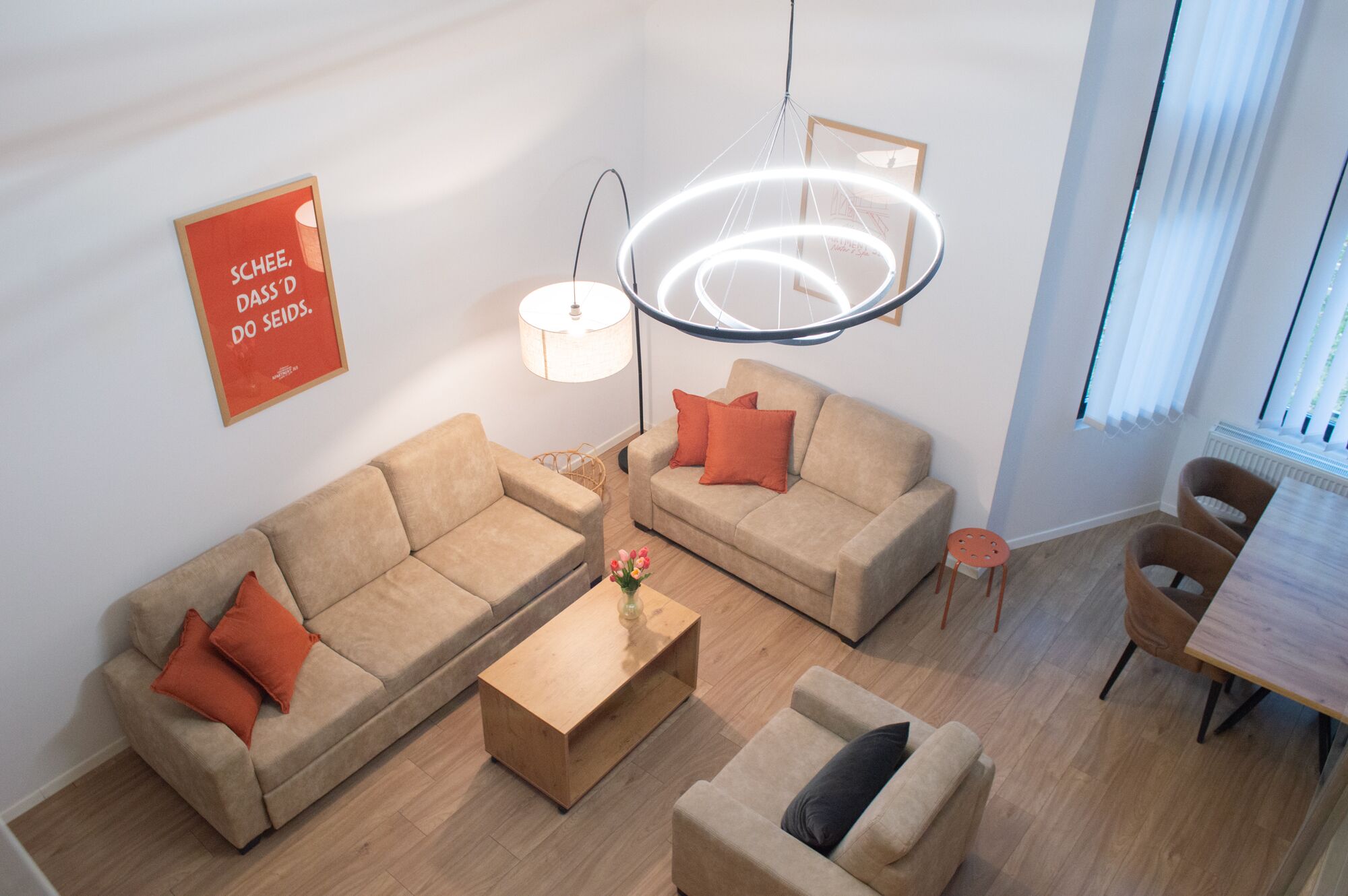Un salon moderne avec deux canapés, une table basse et un luminaire suspendu.