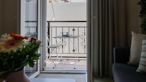 En balkong med ett bord och stolar, en soffa och en krukväxt.