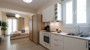 Una cocina moderna con horno empotrado, cafetera y frutero sobre la encimera.