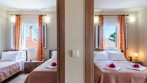 Een spiegelbeeld van een hotelkamer met twee bedden, een nachtkastje, een lamp en een raam met gordijnen.