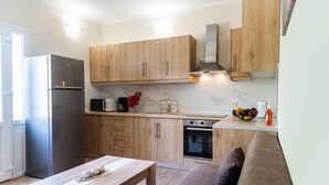 Una cocina moderna con armarios de madera, un refrigerador de acero inoxidable, un microondas y un horno.