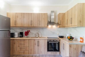 A modern kitchen with wooden cabinets, a built-in oven, a microwave, and a coffee maker. - Villa Georgia 2 - A/C in All Rooms - Fast Wi-Fi - Sleeps 6 (Lefkimmi)