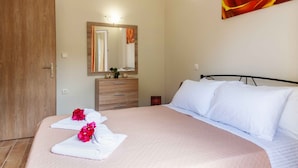 Un dormitorio con una cama, un aparador, un espejo y un cuadro en la pared.