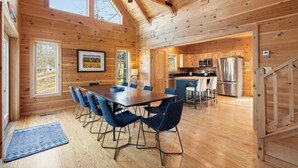 A wooden cabin with a dining area, kitchen, and a staircase. - The Keowee Hideaway• Lakefront • 25 min to Clemson (Seneca)