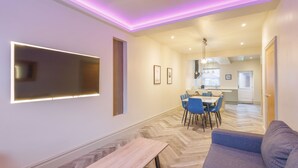 Un salon moderne avec un canapé, une table basse et un téléviseur fixé au mur.