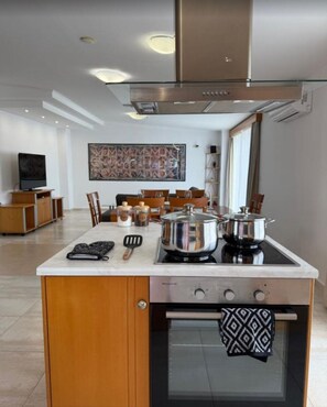A modern kitchen with an island, built-in oven, and stainless steel appliances. - Castle & Sea Panorama Penthouse
 A short walk from Haraki seafront (Charaki)
