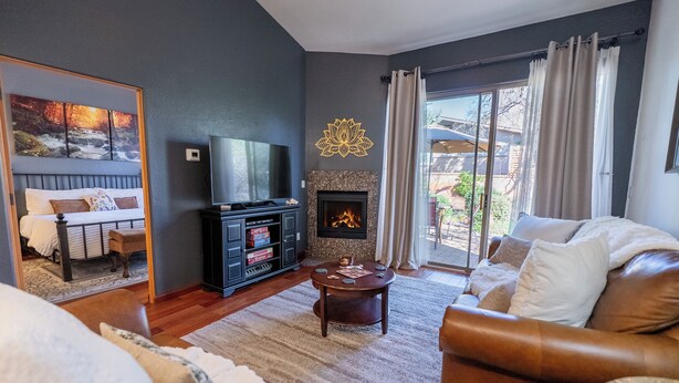 Una sala de estar con chimenea, sofá de cuero y televisor.