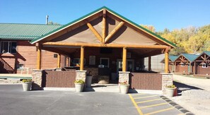 Un chalet doté d’une entrée couverte, portant le numéro 1105, avec une façade en pierre et des piliers en bois.