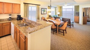 A hotel room with a kitchen area, dining table, chairs, and a view of the ocean. - Ocean Front Condo in North Myrtle Beach. 
2 bedroom 2 bath w/direct beach access (Myrtle Beach)