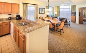 A hotel room with a kitchen area, dining table, chairs, and a view of the ocean. - Ocean Front Condo in North Myrtle Beach. 
2 bedroom 2 bath w/direct beach access (Myrtle Beach)