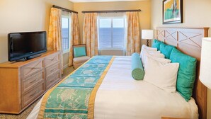 A hotel room with a bed, a TV, a desk, and a window with curtains. - Ocean Front Condo in North Myrtle Beach. 
2 bedroom 2 bath w/direct beach access (Myrtle Beach)