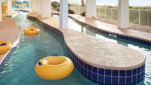 A swimming pool with a pebble-lined edge, yellow floating rings, and a tiled deck area. - Ocean Front Condo in North Myrtle Beach. 
2 bedroom 2 bath w/direct beach access (Myrtle Beach)