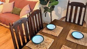 Ein Essbereich mit einem Holztisch, gedeckt für vier Personen, umgeben von Holzstühlen.
