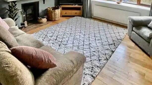 A living room with a grey sofa, a patterned rug, a TV, and a fireplace. - Spacious Village House near Oxford with Woodburner (Horspath)