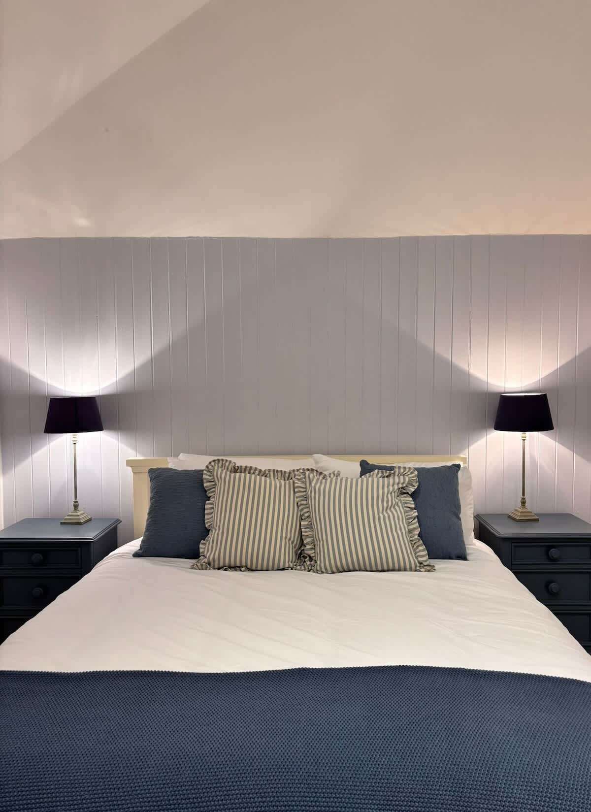 Una camera da letto con un letto, due comodini e due lampade.