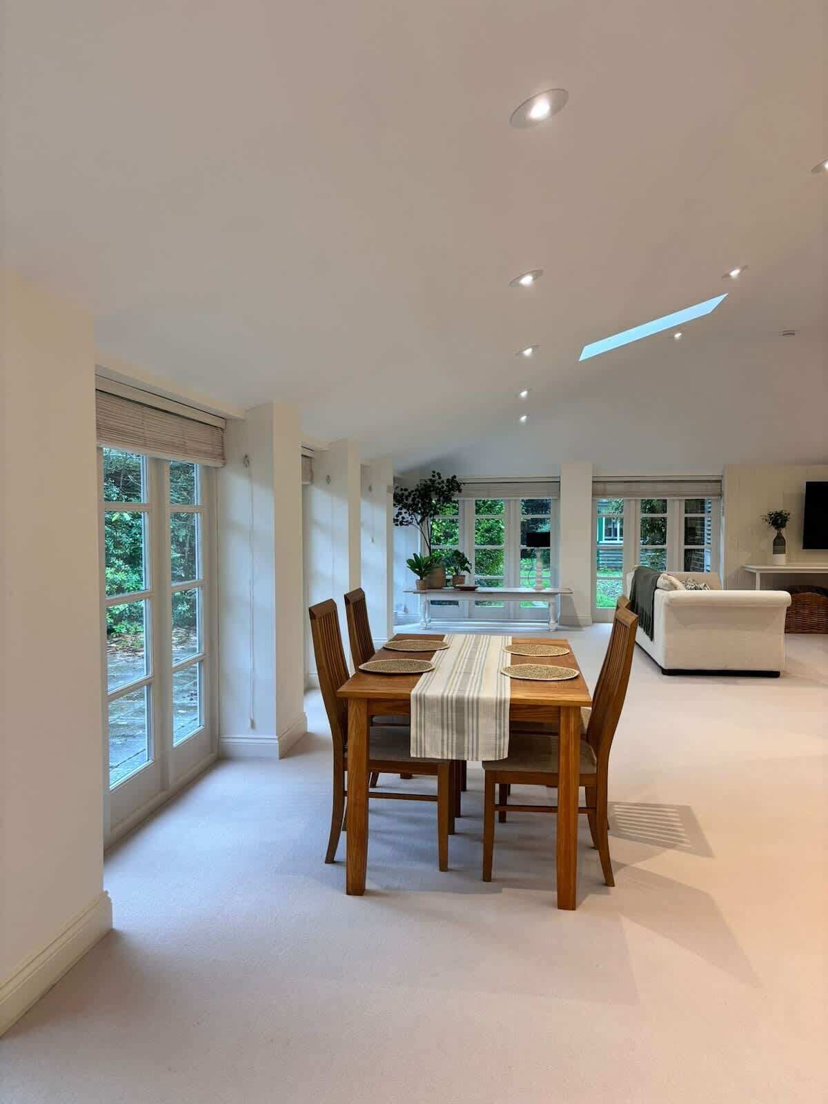 Un salón comedor espacioso con ventanas amplias y un diseño de techo moderno.