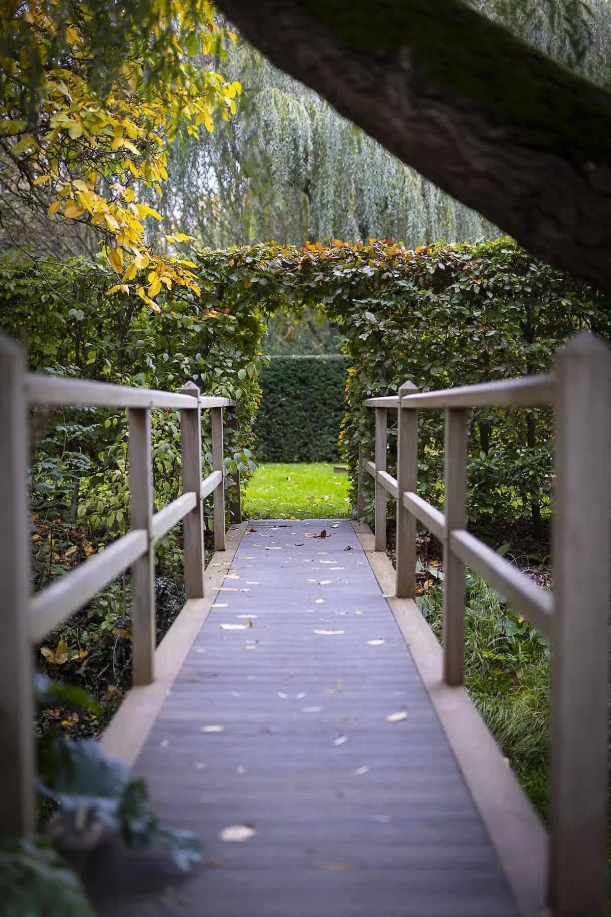 Un ponte di legno con ringhiere che conduce a una zona verde.