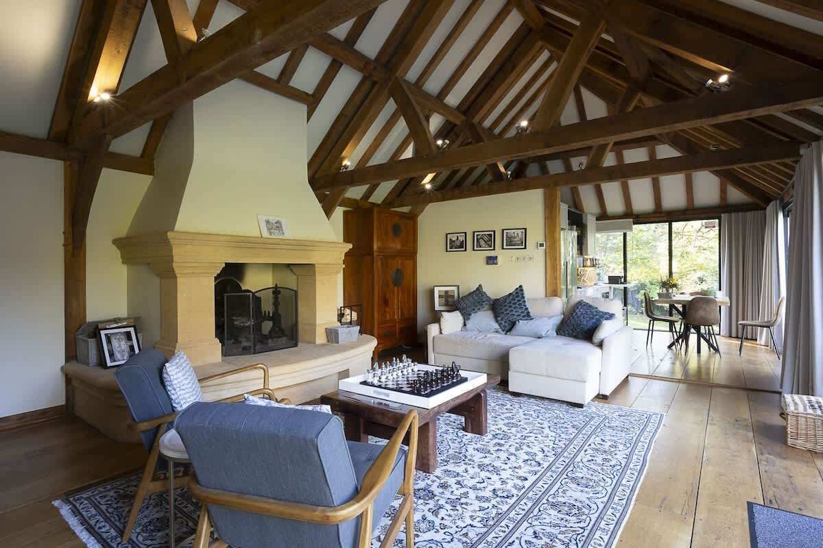A spacious living room with a fireplace, a chess table, and a cozy seating area.