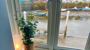 A view from a window with a table, a plant, and a lamp.