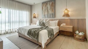 Een moderne slaapkamer met een groot bed, nachtkastjes, een geweven lamp en een kunstwerk aan de muur.