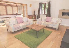 A living room with two sofas, a coffee table, and a green rug. - Walworth Castle Lodge (Darlington)