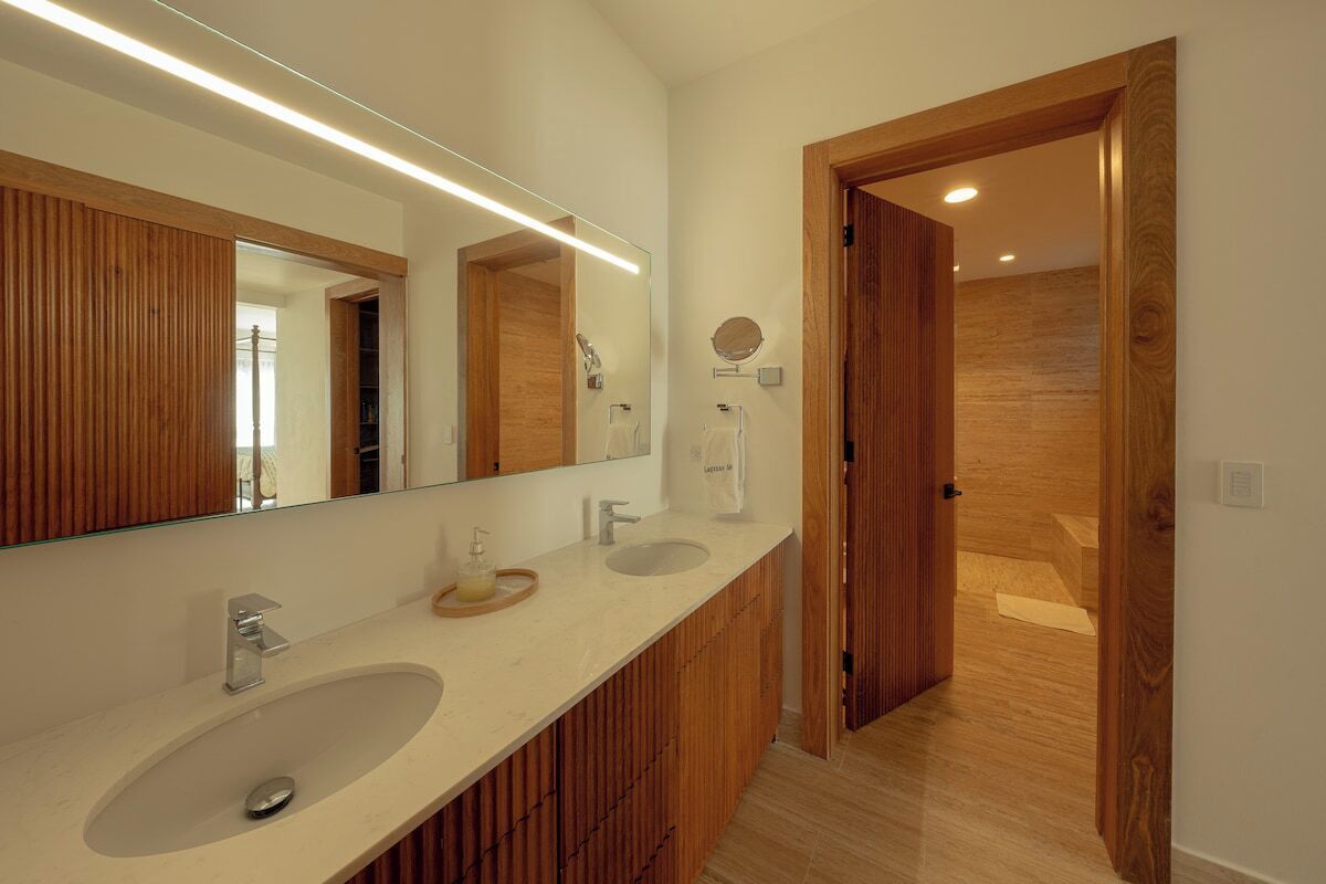 Een moderne badkamer met twee wasbakken, een grote spiegel en houten lambrisering.