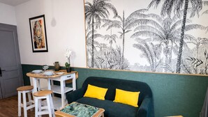 A cozy room with a green sofa, two yellow cushions, a wooden coffee table, and a white table with a plant. - Parenthèse Urbaine in Armentières (Armentières)