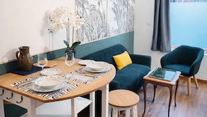 A dining area with a wooden table, white chairs, and a wall mural. - Parenthèse Urbaine in Armentières (Armentières)