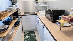 A compact kitchen with a washing machine, a microwave, and a small sink. - Parenthèse Urbaine in Armentières (Armentières)