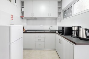 A modern kitchen with white cabinets, a refrigerator, a coffee maker, and a microwave. - Spectacular view of Porto and Douro-Free Parking (Vila Nova de Gaia)