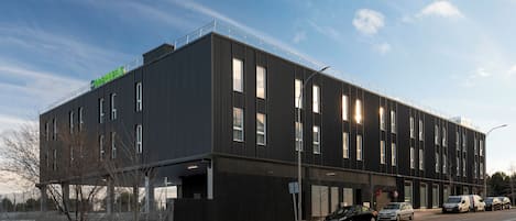Un bâtiment moderne doté d’un toit plat, de grandes fenêtres et d’une enseigne bien visible.