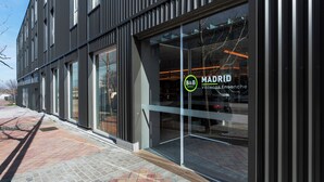 A modern building with large glass windows and a sign for B&B MADRID. - B&B HOTEL Madrid Vallecas Ensanche (Madrid)