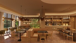 Ein modernes Restaurant mit einer gemütlichen Sitzecke, einer Buffettheke und einer im Hintergrund sichtbaren Küche.
